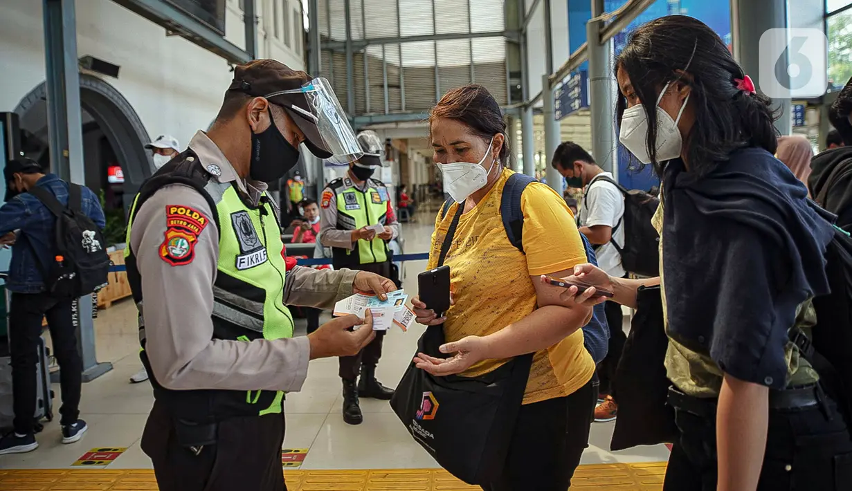 Petugas melayani calon penumpang kereta di Stasiun Pasar Senen, Jakarta, Jumat (24/12/2021). Penambahan jumlah kereta jarak jauh diharapkan mampu mengakomodir penumpang yang melakukan perjalanan selama libur Natal dan Tahun Baru. (Liputan6.com/Faizal Fanani)