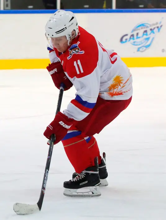 Presiden Rusia Vladimir Putin saat mengikuti Night Hockey League bersama Presiden Belarusia Alexander Lukashenko di Sochi, Rusia, Jumat (7/2/2020). Putin dan Lukashenko bermain hoki bersama saat jeda pembicaraan ekonomi antara kedua negara. (Mikhail Klimentyev, Sputnik, Kremlin Pool Photo via AP)