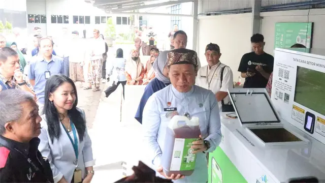 Bupati Samani mencoba mengoperasikan mesin UCollect pertama di area pabrik SKT Karangbener Kudus. (Liputan6.com/Arief Pramono)