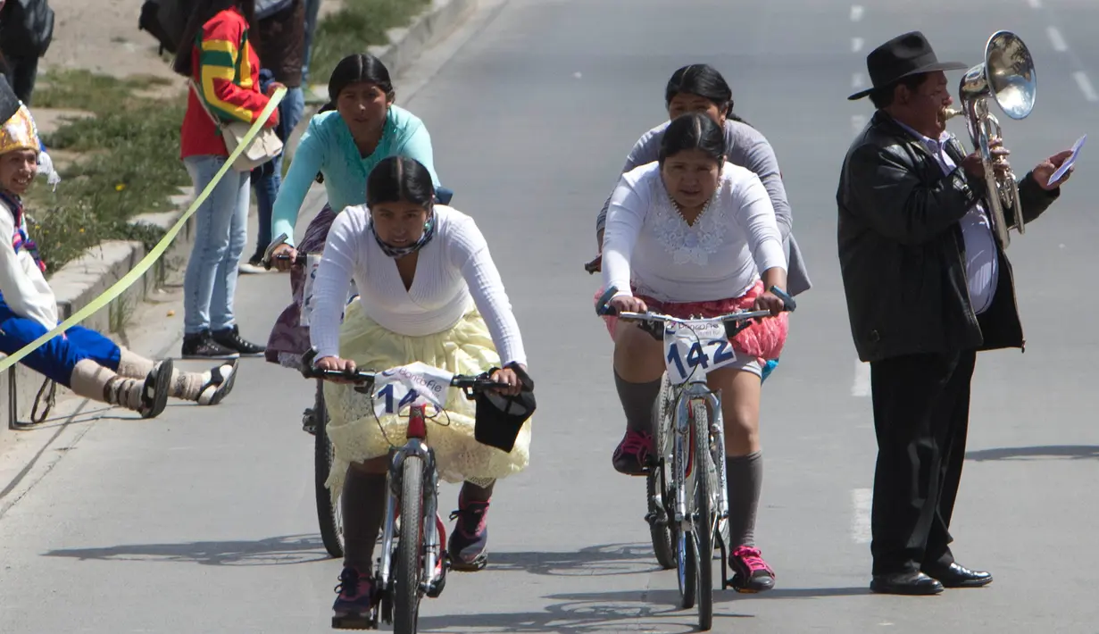 Sejumlah wanita mengayuh sepedanya saat mengikuti balapan Cholita di El Alto, La Paz, Bolivia (12/11). Dalam balapan sepeda ini peserta mengenakan topi bundar, rok dan selendang sulaman. (AP Photo / Juan Karita)