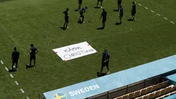 Tim Swedia berpose di sebelah tanda bertuliskan "Get Well Christian" untuk gelandang Denmark Christian Eriksen selama sesi latihan di stadion La Cartuja di Seville, Spanyol, Minggu (13/6/2021). Swedia akan bertanding melawan Spanyol pada Grup E Euro 2020.  (AP Photo/Thanassis Stavrakis)
