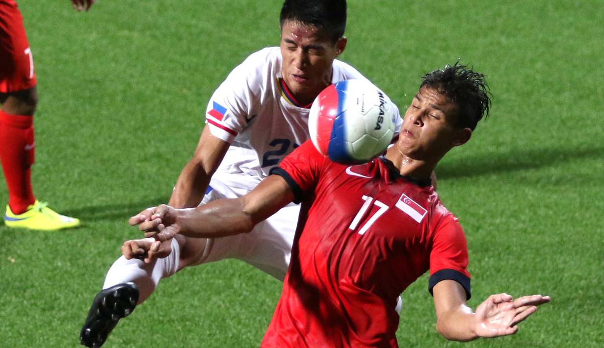 Pemain Singapura, Irfan Fandi Ahmad (kanan) berebut bola dengan pemain Filipina, Shirmar Felongco. (Bola.com/Arief Bagus)