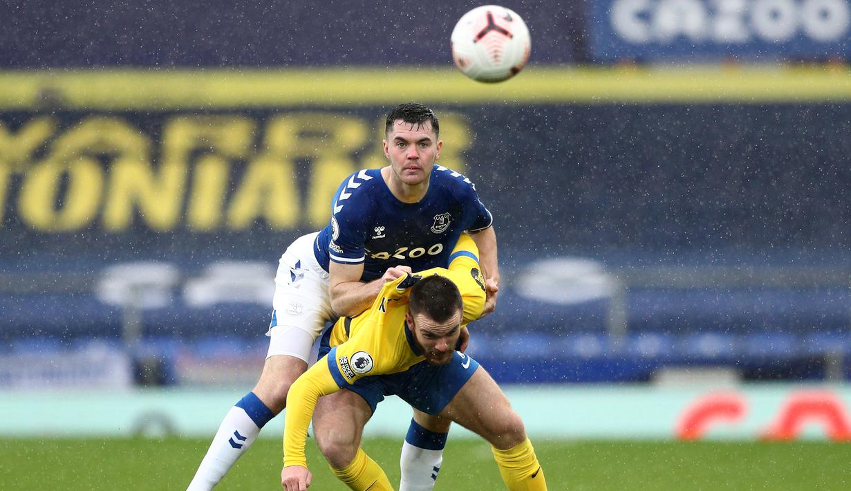 Bek Everton, Michael Keane, berebut bola dengan penyerang Brighton, Aaron Connolly, pada laga lanjutan Liga Inggris di Stadion Goodison Park, Sabtu (3/10/2020) malam WIB. Everton menang 4-2 atas Brighton. (AFP/Jan Kruger/pool)