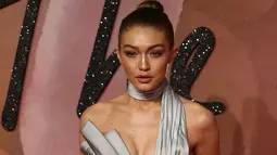 Supermodel Gigi Hadid berpose di karpet merah acara Fashion Awards 2016 di London, Senin (5/12). Pacar Zayn Malik ini tampil mengesankan dengan jumpsuit simetris warna silver yang futuristik. (REUTERS/Neil Hall)