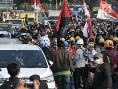 Sejumlah kendaraan berusaha melintas di antara massa pengunjuk rasa yang memasuki Tol Dalam Kota dekat Gedung DPR,  Jakarta, Senin (30/9/2019). Kendaraan yang melintasi terjebak bentrokan antara massa dan polisi yang terjadi di dua sisi sehingga terpaksa berputar arah. (merdeka.com/Iqbal S Nugroho)