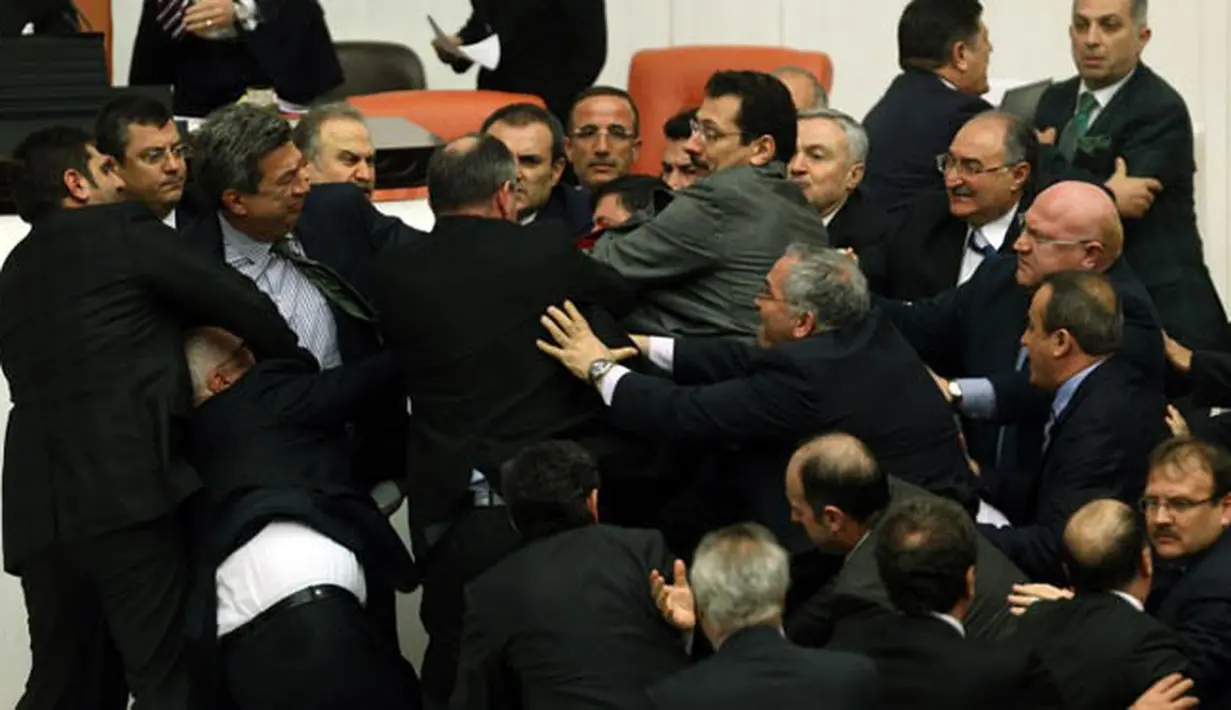 Aksi perkelahian antara anggota parlemen partai oposisi (CHP) dan partai berkuasa AK saat pembahasan undang-undang untuk meningkatkan kekuatan polisi di Ankara, Turki, Kamis (19/2). (AFP PHOTO/ADEM ALTAN)