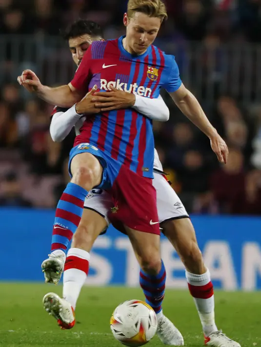 <p>Gelandang Barcelona, Frenkie de Jong mengontrol bola dari kawalan gelandang Rayo Vallecano, Oscar Valentin pada pertandingan lanjutan La Liga Spanyol di stadion Camp Nou di Barcelona, Spanyol, Senin (25/4/2022). Barcelona tumbang atas Rayo Vallecano 0-1. (AP Photo/Joan Monfort)</p>