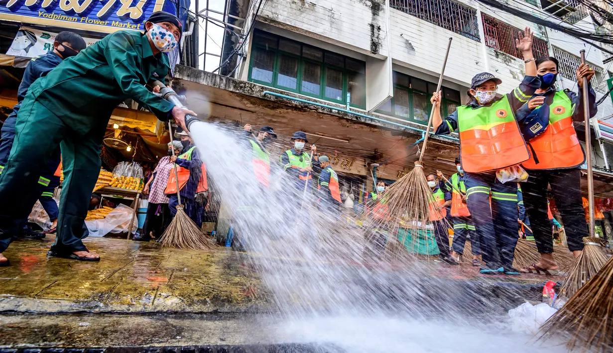 Pekerja Otoritas Metropolitan Bangkok menyapu membersihkan dan mendisinfeksi Pasar Bunga Yodpiman di Bangkok (6/1/2021). Total kematian meningkat menjadi 65 orang di Thailand. (AFP/Mladen Antonov)