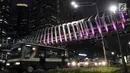 Kendaraan melintas di bawah jembatan penyeberangan orang (JPO) Gelora Bung Karno (GBK), Jakarta, Senin (25/2).   JPO GBK memiliki keunikan dalam segi arsitektur dan keindahan gemerlap lampu pada malam hari. (Merdeka.com/Iqbal S Nugroho)