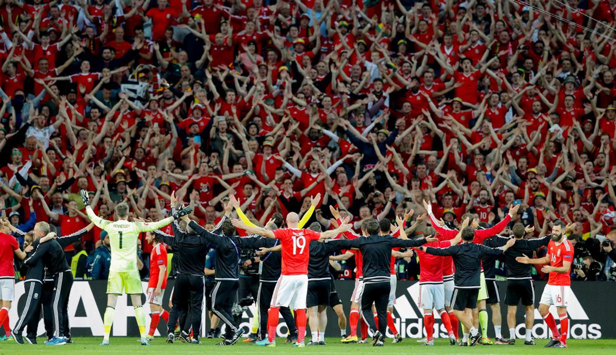 Pemain Wales bergembira bersama pendukungnya setelah menang 3-1 melawan Belgia pada laga perempatfinal Piala Eropa 2016 di Stadion Pierre Mauroy, Lille, Prancis, (1/7/2016). (AP Photo/ Michel Spingler)