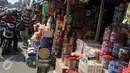 Pengendara motor membeli kue di kios penjual kue kering musiman di kawasan Ciracas, Jakarta, Minggu (12/7). Sejak beberapa hari terakhir, transaksi pedagang musiman kue kering mengalami peningkatan jelang hari raya Idul Fitri. (Liputan6.com/Helmi Afandi)