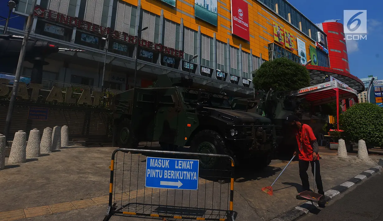 Petugas kebersihan menyapu di depan kendaraan lapis baja TNI di pertokoan Glodok, Jakarta, Jumat (11/5). Pengamanan ketat dilakukan guna antisipasi peristiwa yang tidak diinginkan terkait Aksi Bela Palestina di Monas. (Merdeka.com/Imam Buhori)