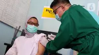 Vaksinator menyuntikkan vaksin COVID-19 kepada tenaga kesehatan yang bertugas di Puskesmas Jurang Mangu, Tangerang Selatan, Jumat (15/1/2021). Program vaksinasi COVID-19 tahap pertama kepada tenaga kesehatan mulai dilakukan di berbagai daerah di Indonesia. (Liputan6.com/Angga Yuniar)