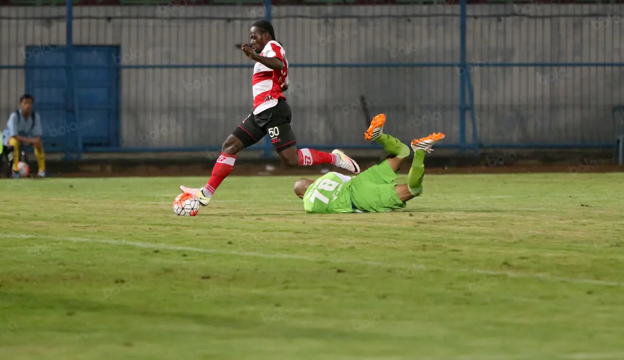 Pemain Madura United, Eric Weeks mengecoh Kiper Persiba Balikpapan, Alfonso pada laga Torabika SC 2016 di Stadion Gelora Bangkalan, Senin(13/6/2016).  (Bola.com/Nicklas Hanoatubun)