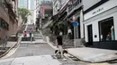 Etienne Simonnet berjalan dengan anjing angkatnya Ah Po, yang ditangani Hong Kong Dog Rescue (HKDR) dan kelompok lain di Hong Kong, 14 April 2020. Sejak pandemi Covid-19, kelompok kesejahteraan hewan HKDR berusaha berjuang lantaran semua acara penggalangan dana dibatalkan. (Anthony WALLACE/AFP)