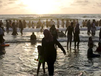 Sejumlah warga Palestina menikmati liburan di pantai Tel Aviv, Israel, Minggu (19/7/2015). Selama Idul Fitri, pemerintah Israel mengizinkan warga Palestina untuk berwisata di sepanjang garis pantai Mediterania. (REUTERS/Baz Ratner)