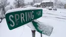 Salju menyelimuti plang nama jalan usai terjadi badai salju di Plainfield Manville, New Jersey (21/3). Salju tebal yang menutup jalanan ini berpotensi membahayakan warganya. (AP/Julio Cortez)