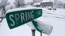 Salju menyelimuti plang nama jalan usai terjadi badai salju di Plainfield Manville, New Jersey (21/3). Salju tebal yang menutup jalanan ini berpotensi membahayakan warganya. (AP/Julio Cortez)