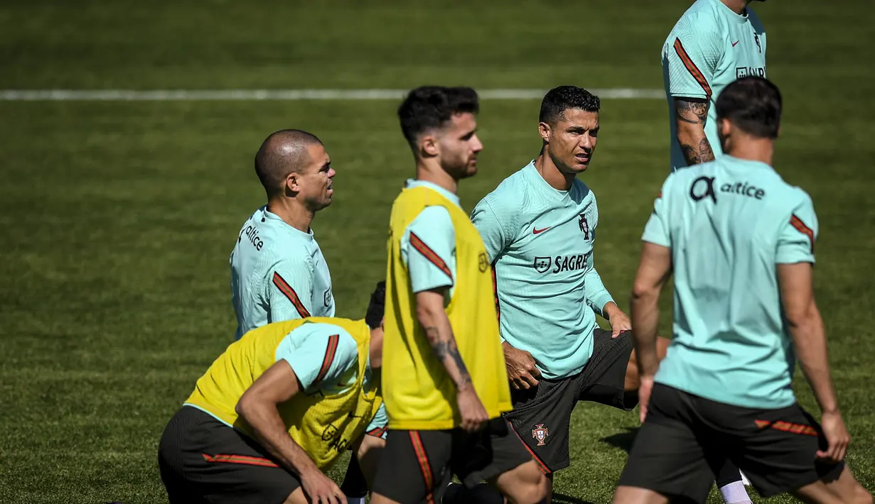 Penyerang Portugal, Cristiano Ronaldo (tengah) dan rekan satu timnya menghadiri sesi latihan dalam persiapan untuk Euro 2020 di kamp pelatihan "Cidade do Futebol" di Oeiras, Senin (7/6/2021). Portugal tergabung dalam Grup F Euro 2020 bersama Perancis, Jerman, dan Hongaria. (PATRICIA DE MELO MOREIRA/
