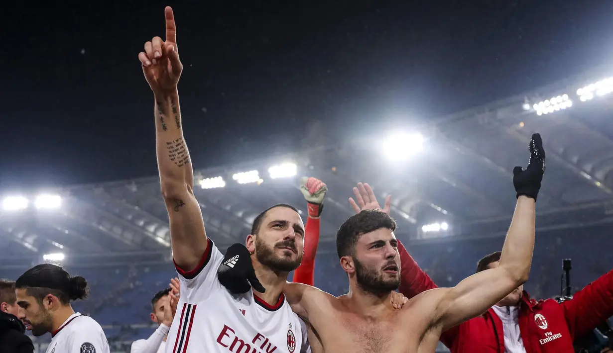 Pemain AC Milan, Leonardo Bonucci (kiri) dan Patrick Cutrone merayakan kemenangan usai menundukkan Lazio pada semifinal Coppa Italia di Stadio Olimpico, Roma, Italia, Rabu (28/2). (Angelo Carconi/ANSA via AP)