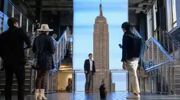 Pengunjung berfoto di Empire State Building, New York pada 9 November 2021. Turis asing yang mendatangi Amerika Serikat disambut kembali ke New York City untuk pertama kalinya dalam 20 bulan setelah pembatasan perjalanan pandemi Covid-19 dicabut. (ANGELA WEISS / AFP)