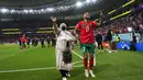 Pemain Maroko, Sofiane Boufal, merayakan kemenangan atas Portugal bersama keluarganya pada laga perempat final di Stadion Al-Thumama, Sabtu (10/12/2022). (AP/Petr David Josek)