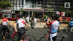Sejumlah pesepeda mengambil gambar gedung utama Kejaksaan Agung RI yang terbakar di Jalan Sultan Hasanuddin, Jakarta Selatan, Minggu (23/8/2020).  Banyak warga yang memadati Jalan Hasanuddin untuk melihat langsung kondisi gedung Kejaksaan Agung yang hangus dilalap api. (Liputan6.com/Faizal Fanani)