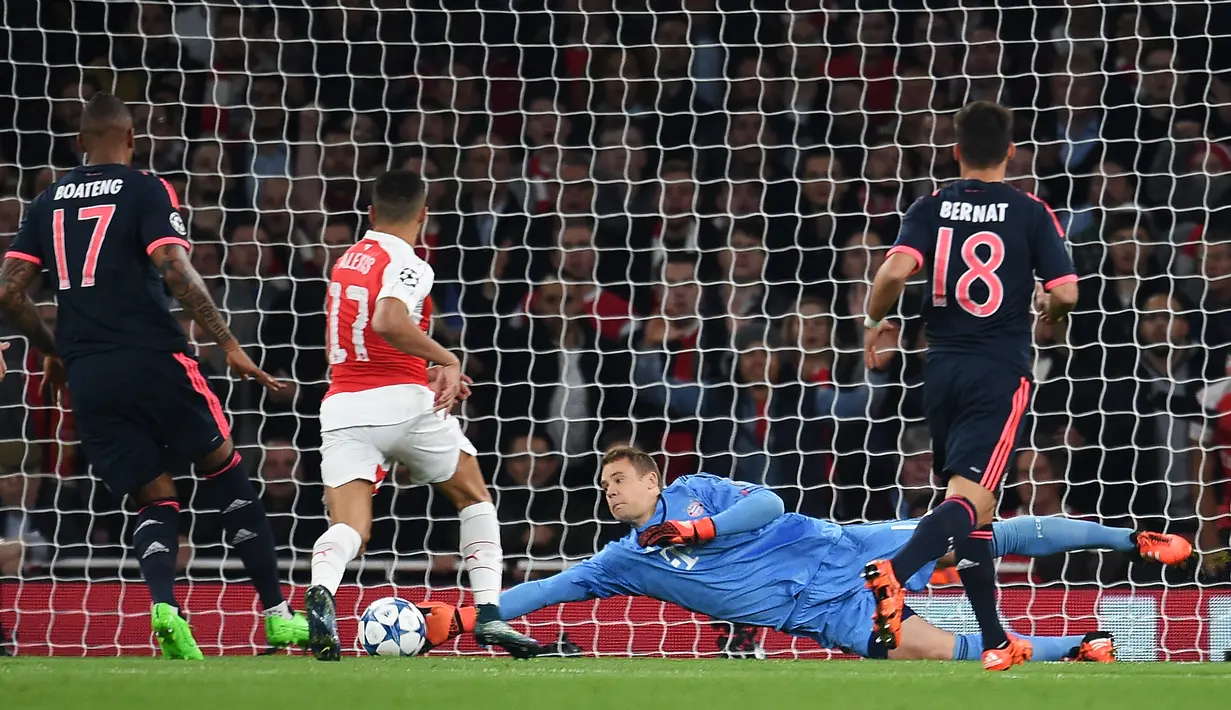 Kiper Munchen, Manuel Neuer, mengamankan gawangnya dari serangan pemain Arsenal dalam laga Grup F Liga Champions di Stadion Emirates, London, Rabu (21/10/2015) dini hari WIB. (EPA/Andy Rain)