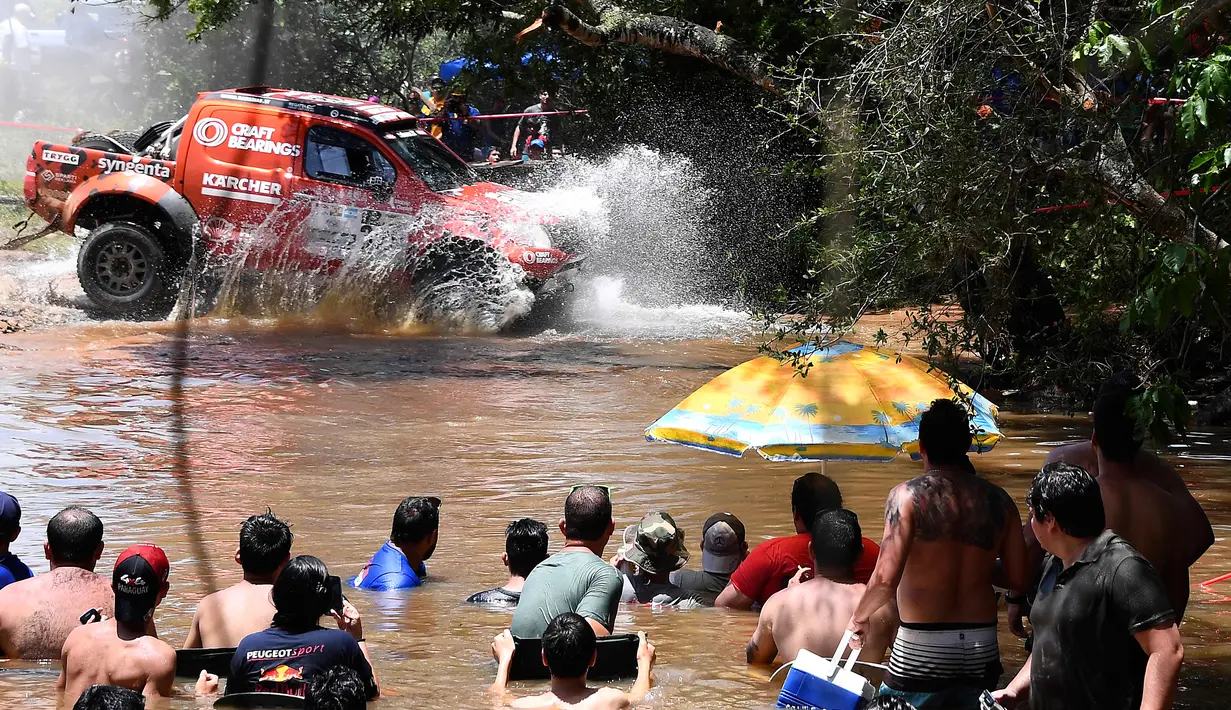 Sejumlah orang menonton aksi para pereli saat Reli Dakar 2017 etape 1 antara Asuncion dan Resistencia, di Argentina, Senin (2/1). Sebanyak 12 etape harus ditaklukan oleh para pereli untuk menjadi yang terbaik di Reli Dakar 2017. (AFP PHOTO / FRANCK FIFE)