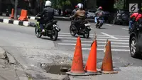 Pengendara menghindari jalan berlubang di kawasan Tanjung Barat, Jakarta, Rabu (30/1). Kondisi jalan rusak tersebut telah beberapa kali menyebabkan kecelakaan sehingga butuh penanganan. (Liputan6.com/Immanuel Antonius)