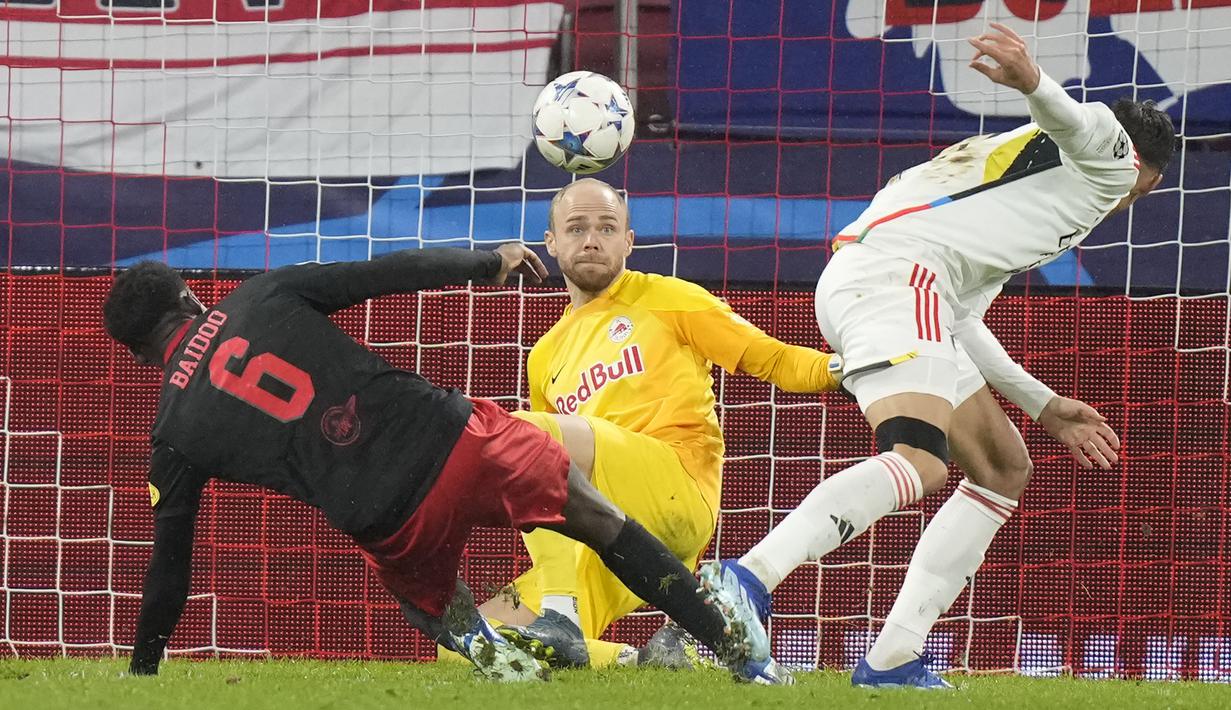 Kiper RB Salzburg, Alexander Schlager (tengah) berhasil mementahkan tendangan striker Benfica, Petar Musa pada laga matchday keenam Grup D Liga Champions 2023/2024 di Red Bull Arena, Salzburg, Austria, Rabu (13/12/2023) dini hari WIB. (AP Photo/Matthias Schrader)