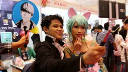 Dua orang cosplay sedang selfie pada gelaran Popcon Asia 2016 di Jakarta Convention Center (JCC), Jakarta (14/08). Festival yang berlangsung 12-14 Agustus diikuti 225 booth pegiat kreatif tanah air. (Liputan6.com/Fery Pradolo)