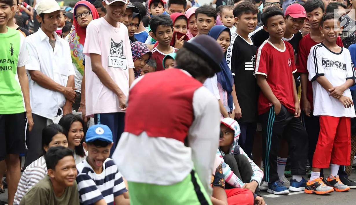 Pengunjung melihat penampilan seniman pantomin saat car free day di Jakarta, Minggu (1/7). Aksi tersebut dilakukan guna mengumpulkan biaya yang akan digunakan untuk menikah. (Liputan6.com/Immanuel Antonius)