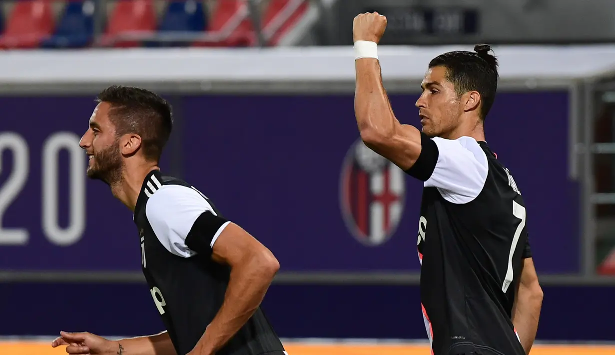 Penyerang Juventus, Cristiano Ronaldo (kanan) berselebrasi usai mencetak gol kegawang Bologna pada pertandingan lanjutan liga Serie A Italia di stadion Renato-Dall'Ara di Bologna (22/6/2020). Juventus menang 2-0 atas Bologna. (Miguel MEDINA / AFP)