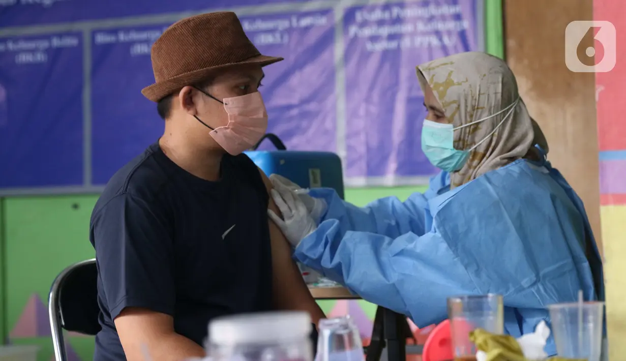 Petugas kesehatan menyuntikkan vaksin covid-19 kepada warga di kawasan Tanah Tinggi, Kota Tangerang, Jumat (4/3/2022). Pemkot Tangerang mengadakan operasi pasar minyak dan daging murah bagi warga yang melaksanakan vaksinasi covid-19 di lokasi. (Liputan6.com/Angga Yuniar)