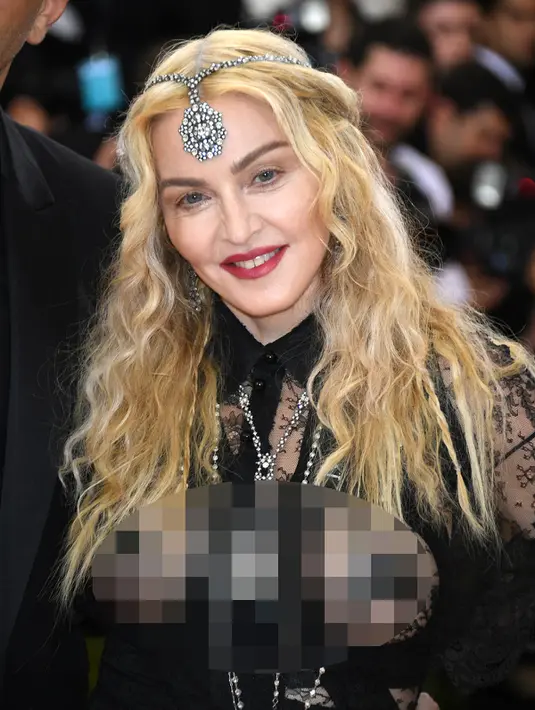 Senyum Madonna saat berpose menghadiri ajang Met Gala 2016 di Metropolitan Museum of Art, New York, Senin (2/5). Madonna hadir bersama desainer Riccardo Tisci dengan busana yang nyentrik dan transparan. (AFP/Larry Busacca)