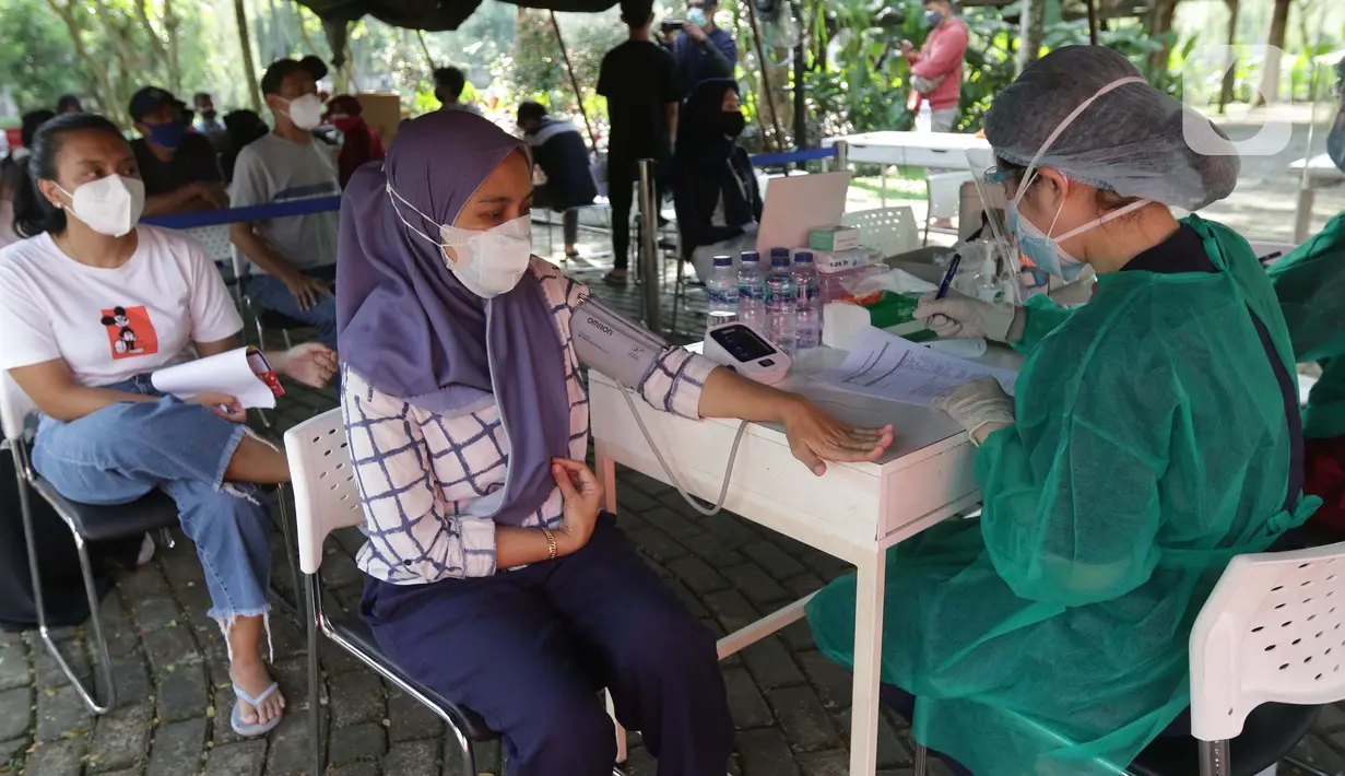 Warga di cek kesehatannya jelang vaksinasi COVID-19 melalui mobil vaksin keliling di Taman Dadap Merah, Kebagusan, Jakarta, Sabtu (10/7/2021). Pelaksanaan vaksinasi melalui mobil vaksin keliling juga diperuntukkan untuk anak usia 12 tahun ke atas. (Liputan6.com/Helmi Fithriansyah)