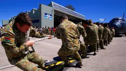 Anggota Angkatan Darat Australia menarik sebuah pesawat C-130J Hercules seberat 40 ton lebih dari jarak sepuluh meter di Royal Australian Air Force (RAAF) Base di Richmond, Australia, Kamis (24/11). (REUTERS / David Gray)
