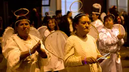 Sejumlah wanita mengenakan kostum peri menari saat parade Natal tahunan di La Paz, Bolivia (24/11). Para peserta juga mengenakan kostum bintang, peri, kepingan salju dan tokoh-tokoh lain dalam dongeng Natal. (AP Photo/Juan Karita)