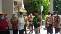 Perwakilan driver Gojek menyerahkan paket makanan dalam mendukng program Buka Bersama On The Screen (BuBOS) Jawa Barat. (Dok:Gojek)