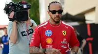 Pembalap Ferrari asal Inggris, Lewis Hamilton, berjalan di paddock pada hari pertama tes pramusim Formula Satu kedua di Sirkuit Internasional Bahrain di Sakhir pada 18 Februari 2026. (Giuseppe CACACE/AFP)