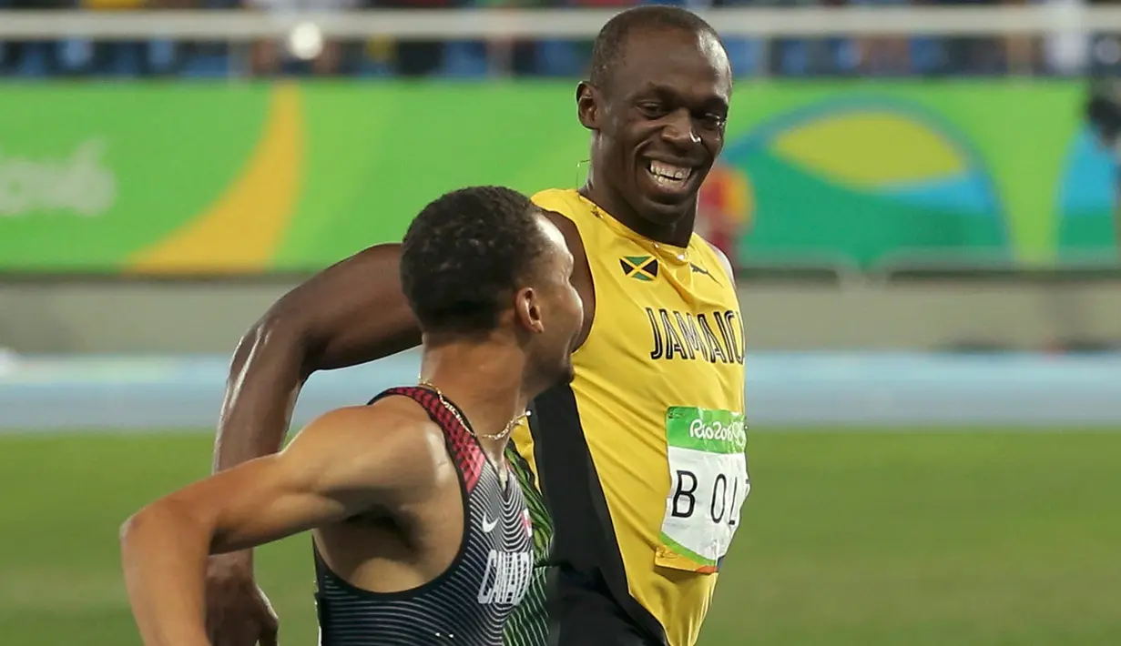  Pelari Asal Jamaika, Usain Bolt tersenyum dengan Andre de Grasse, pelari Kanada saat bersaing di semifinal lari 200 meter pria di Rio de Janeiro, Brasil (17/8). Usain Bolt meraih medali emas kedua di lari 200 meter pria. (REUTERS/Gonzalo Fuentes)