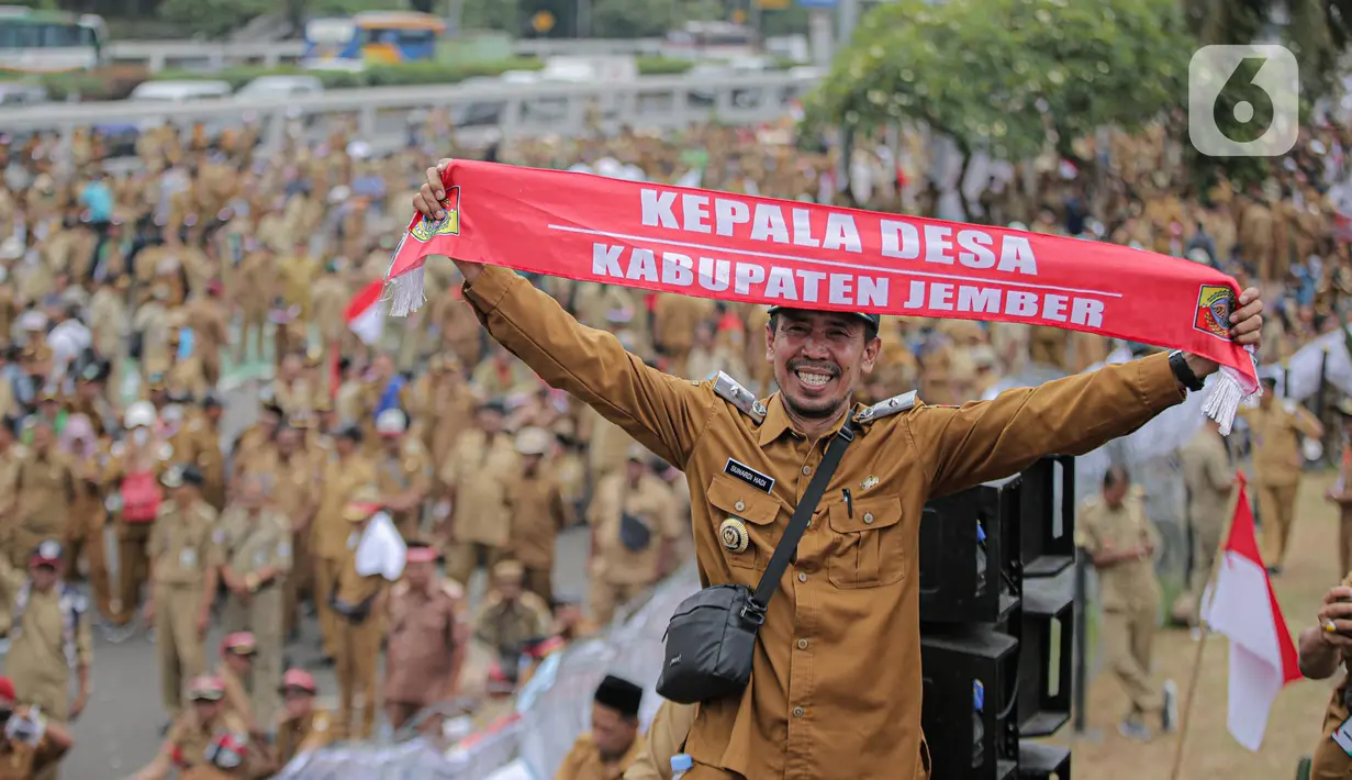 Seorang kepala desa membentangkan syal saat melakukan aksi di depan Gedung DPR RI, Jakarta, Selasa (17/1/2023). Dalam aksi yang diikuti ribuan orang tersebut mereka menuntut perpanjangan masa jabatan kepala desa yang sebelumnya enam tahun menjadi sembilan tahun dan meminta DPR RI merevisi masa jabatan yang diatur dalam UU Nomor 6 Tahun 2014 tentang Desa. (Liputan6.com/Faizal Fanani)