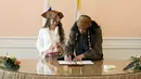 German Yesakov menandatangani surat pernikahan disaksikan calon istrinya Anastasiya di Rusia, (5/2/2016). Yesakov menyiapkan pesta pernikahan bertema 'Pirates of the Caribbean' sebagai kejutan untuk Anastasiya. (REUTERS/Eduard Korniyenko)