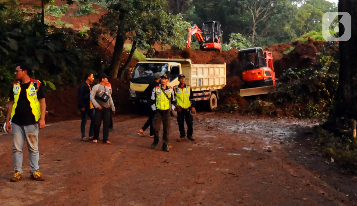 Petugas bekerja di lokasi longsor yang menutup ruas jalan utama Cipanas-Cianjur akibat gempa bumi di kawasan Cugenang, Cianjur, Jawa Barat, Senin (21/11/2022). Longsor membawa sebuah angkot yang diduga berisi penumpang dan truk ke dalam jurang, evakuasi pun akan dilanjutkan esok hari. (merdeka.com/Arie Basuki)