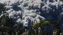 Jack Jones mengambil gambar saat kepulan asap abu vulkanik gunung Kiluaea berembus di country club di Volcano, Hawaii (21/5). Lava dari gunung Kilauea Hawaii mengalir ke laut dan memicu reaksi kimia yang menciptakan asap hitam. (AP Photo/Jae C. Hong)