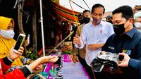 Presiden Joko Widodo (Jokowi) membagikan bantuan langsung tunai (BLT) kepada para pedagang di Pasar Baru Tanjung Enim, Sumatra Selatan, Senin (24/1/2022). Bantuan sebesar Rp1,2 juta per orang itu diberikan Jokowi dengan ditemani Menteri BUMN Erick Thohir. (Dok. Biro Pers Kepresidenan)
