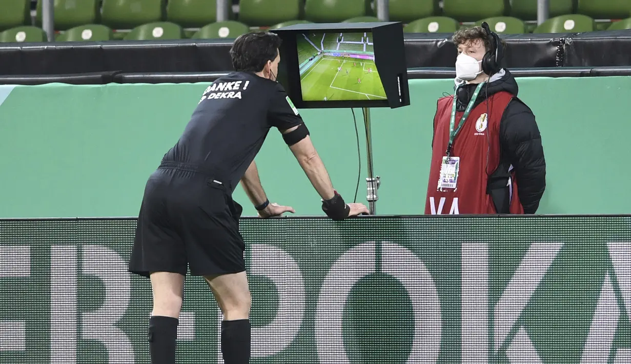 Wasit Manuel Grafe memeriksa rekaman VAR dalam laga semifinal DFB Pokal antara Werder Bremen melawan RB Leipzig di Weserstadion, Bremen, Jumat (30/4/2021). Werder Bremen kalah 1-2 dari RB Leipzig melalui babak perpanjangan waktu. (AP/Carmen Jaspersen/Pool)
