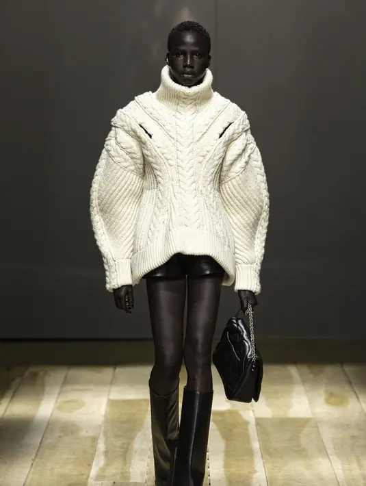 Area bahu dihadirkan secara kuat, sedangkan bagian pinggang dibuat sempit. Celana bertumit memberi siluet kaki yang lebih jenjang. Foto: Document/Alexander McQueen.