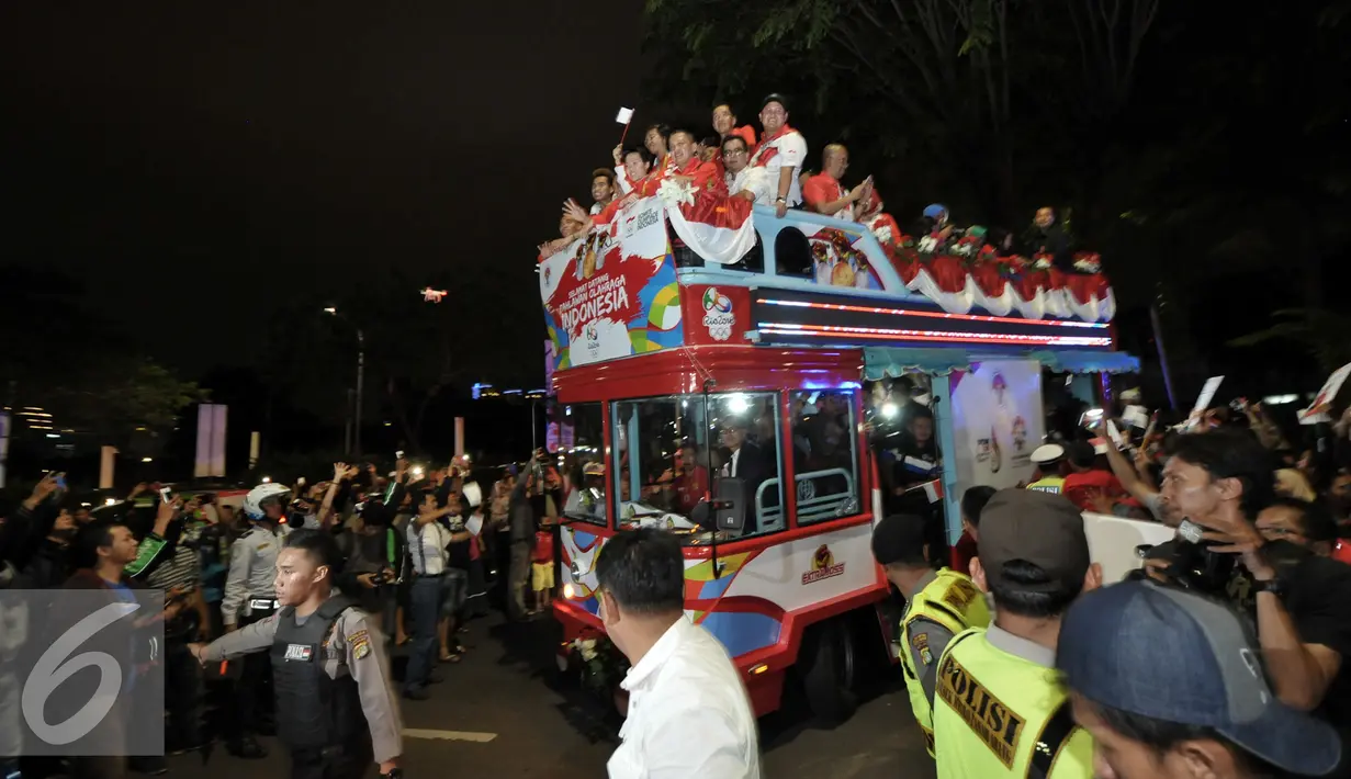 Arak-arakan atlet peraih medali Olimpiade Rio 2016 disambut meriah oleh warga, Senayan, Jakarta, Selasa (23/8). Setibanya di Tanah Air, atlet Olimpiade diarak menggunakan bus Bamdros menuju gedung Kemenpora. (Liputan6.com/Yoppy Renato)